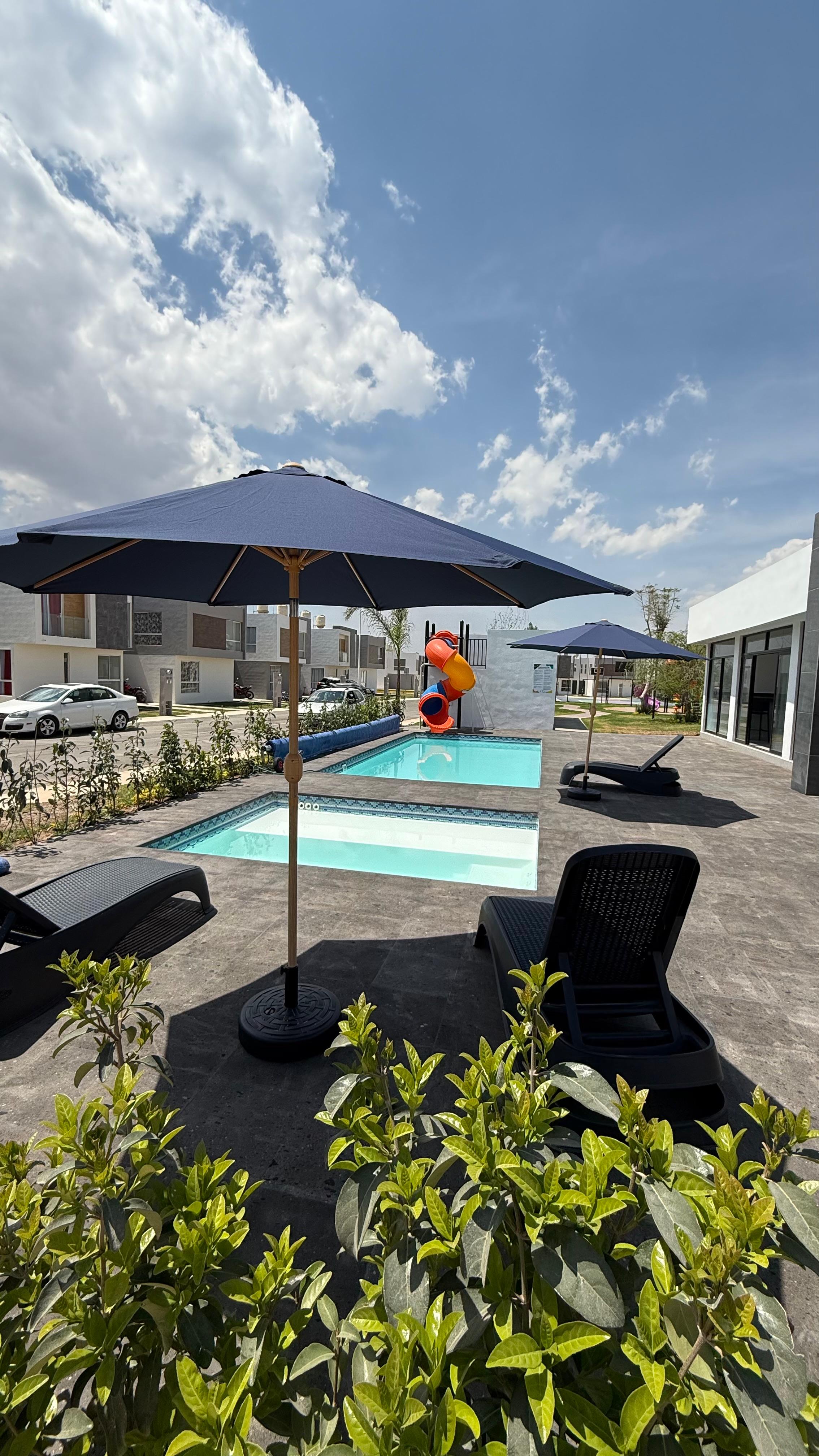 Albercas en desarrollo residencial con sombrillas